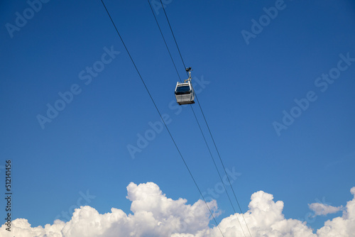 Cable car cabin over blue sky with clouds. Cableway, green transportation. Tbilisi. Georgia.
