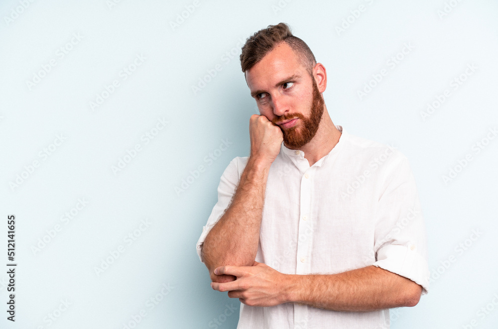 Young caucasian man isolated on blue background who feels sad and pensive, looking at copy space. Young caucasian man isolated on blue background who feels sad and pensive, looking at copy space.