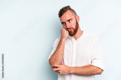 Young caucasian man isolated on blue background who feels sad and pensive, looking at copy space.