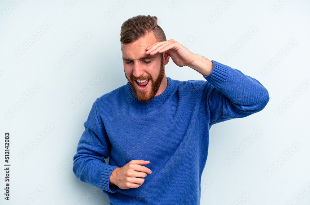 Young caucasian man isolated on blue background joyful laughing a lot. Happiness concept. Young caucasian man isolated on blue background joyful laughing a lot. Happiness concept.