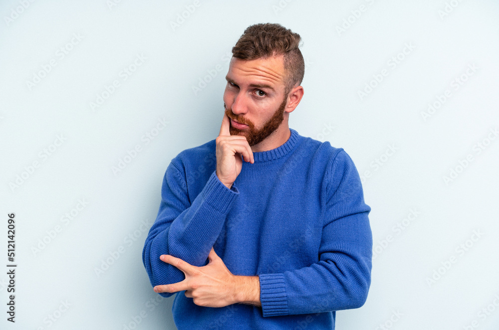 Young caucasian man isolated on blue background contemplating, planning a strategy, thinking about the way of a business. Young caucasian man isolated on blue background contemplating, planning a strategy, thinking about the way of a business.
