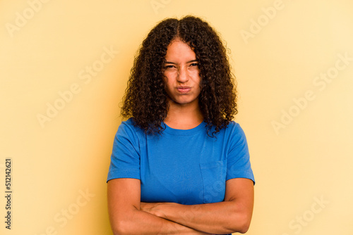 Obraz na plátně Young Brazilian woman isolated on yellow background frowning face in displeasure, keeps arms folded