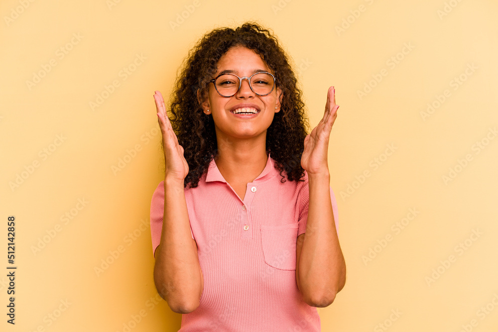 Young Brazilian woman isolated on yellow background laughs out loudly keeping hand on chest. Young Brazilian woman isolated on yellow background laughs out loudly keeping hand on chest.