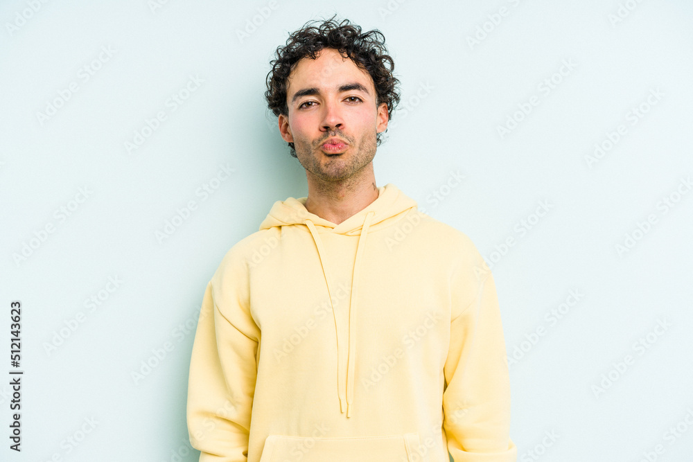 Young caucasian man isolated on blue background blows cheeks, has tired expression. Facial expression concept. Young caucasian man isolated on blue background blows cheeks, has tired expression. Facial expression concept.