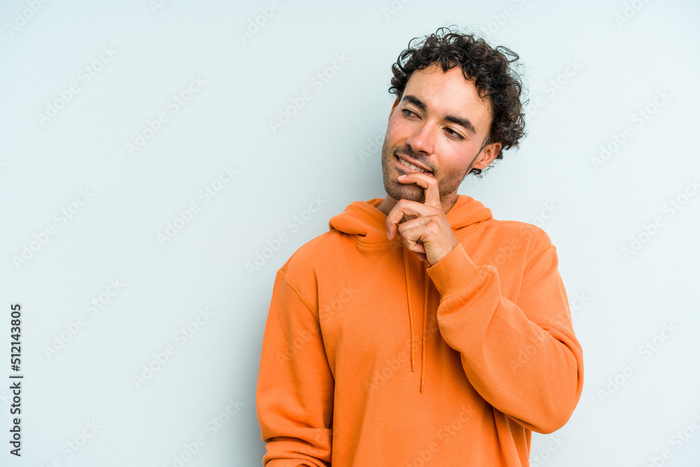 Young caucasian man isolated on blue background relaxed thinking about something looking at a copy space. Young caucasian man isolated on blue background relaxed thinking about something looking at a copy space.