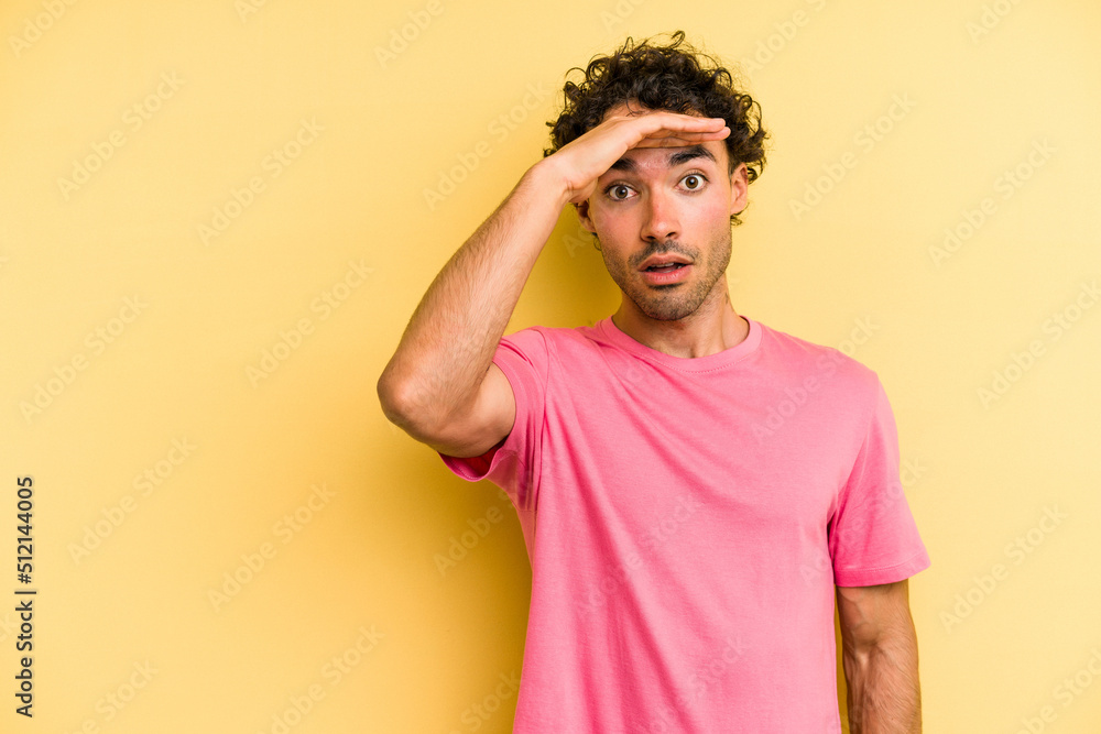 Young caucasian man isolated on yellow background shouts loud, keeps eyes opened and hands tense. Young caucasian man isolated on yellow background shouts loud, keeps eyes opened and hands tense.