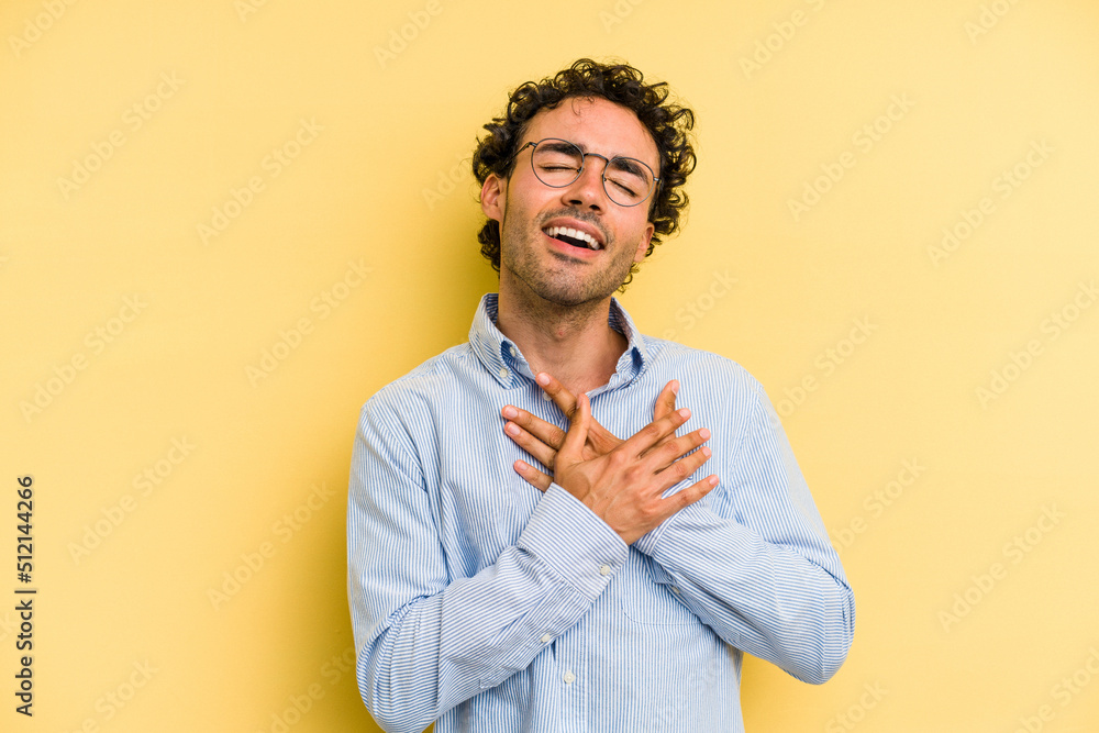 Young caucasian man isolated on yellow background has friendly expression, pressing palm to chest. Love concept. Young caucasian man isolated on yellow background has friendly expression, pressing palm to chest. Love concept.