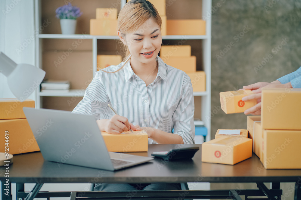 Looking camera, Startup small business SME, Entrepreneur owner using tablet taking receive and checking online purchase shopping order to preparing pack product box Looking camera, Startup small business SME, Entrepreneur owner using tablet taking receive and checking online purchase shopping order to preparing pack product box