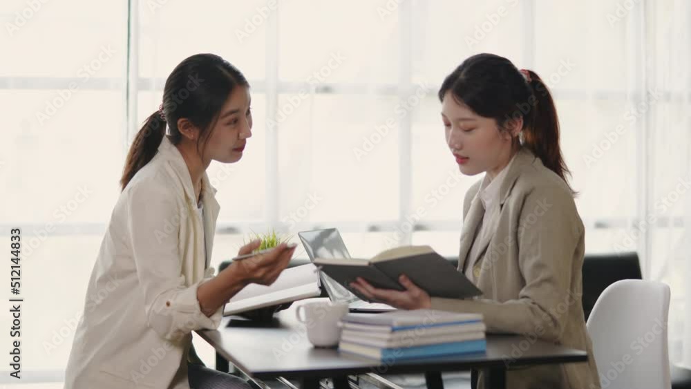 Two young beautiful business women are discussed and explained about works in office space. Two young beautiful business women are discussed and explained about works in office space.
