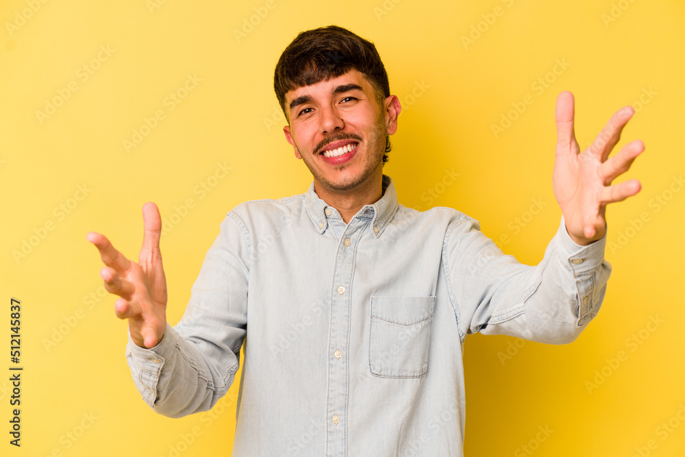 Young caucasian man isolated on yellow background showing a welcome expression. Young caucasian man isolated on yellow background showing a welcome expression.