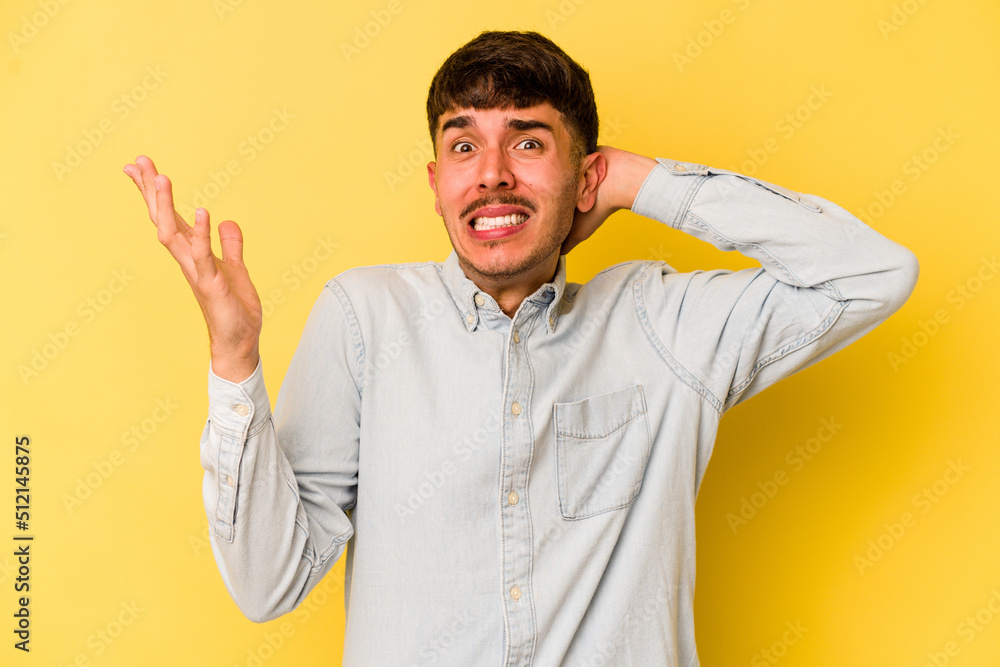 Young caucasian man isolated on yellow background screaming with rage. Young caucasian man isolated on yellow background screaming with rage.
