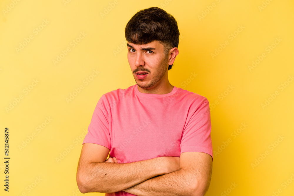 Young caucasian man isolated on yellow background unhappy looking in camera with sarcastic expression. Young caucasian man isolated on yellow background unhappy looking in camera with sarcastic expression.