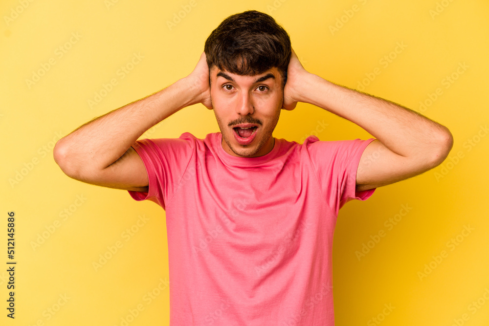 Young caucasian man isolated on yellow background screaming, very excited, passionate, satisfied with something. Young caucasian man isolated on yellow background screaming, very excited, passionate, satisfied with something.