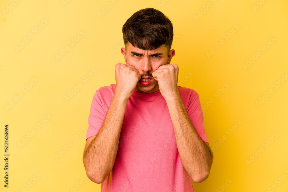 Young caucasian man isolated on yellow background throwing a punch, anger, fighting due to an argument, boxing. Young caucasian man isolated on yellow background throwing a punch, anger, fighting due to an argument, boxing.