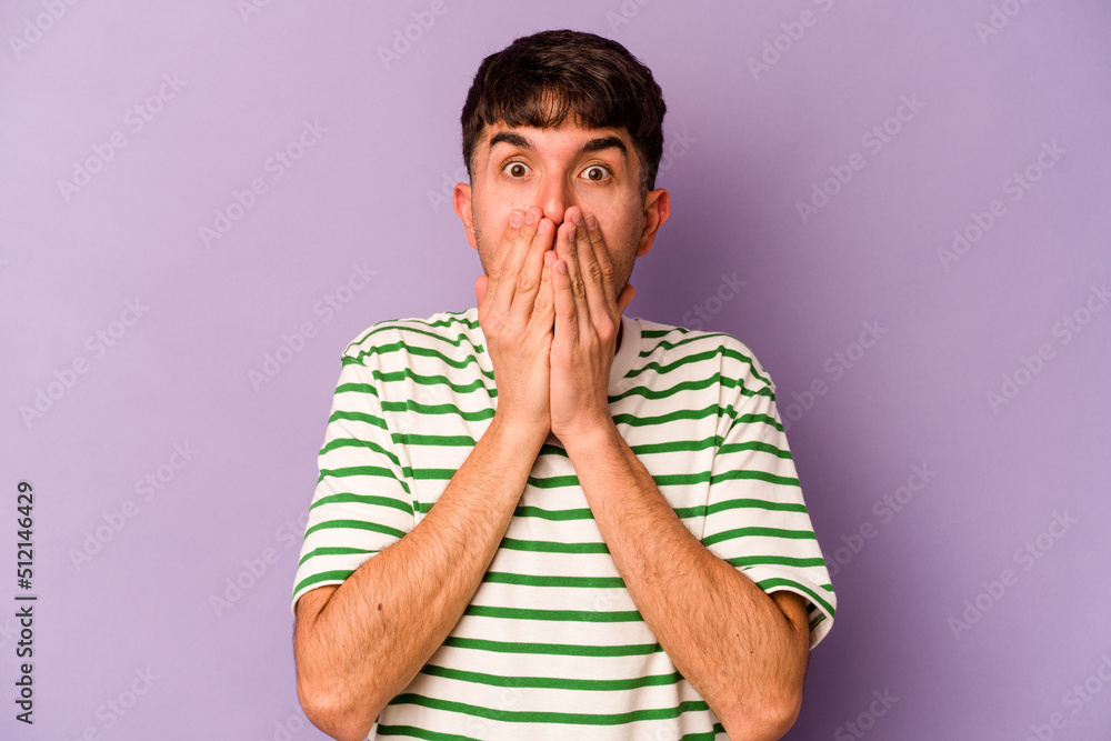 Young caucasian man isolated on purple background shocked, covering mouth with hands, anxious to discover something new. Young caucasian man isolated on purple background shocked, covering mouth with hands, anxious to discover something new.
