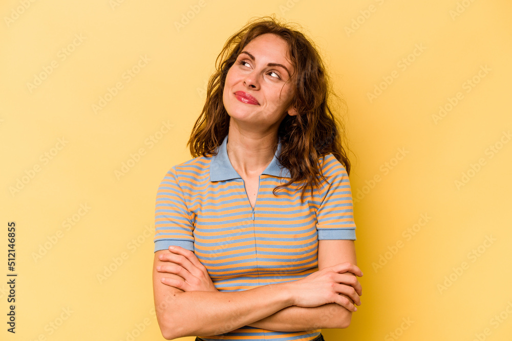 Obraz premium Young caucasian woman isolated on yellow background dreaming of achieving goals and purposes