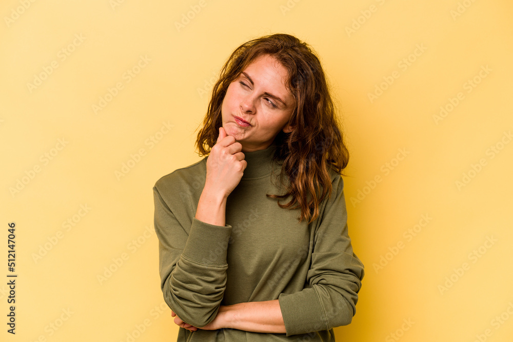 Young caucasian woman isolated on yellow background thinking and looking up, being reflective, contemplating, having a fantasy. Young caucasian woman isolated on yellow background thinking and looking up, being reflective, contemplating, having a fantasy.