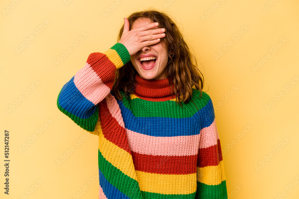 Young caucasian woman isolated on yellow background covers eyes with hands, smiles broadly waiting for a surprise. Young caucasian woman isolated on yellow background covers eyes with hands, smiles broadly waiting for a surprise.