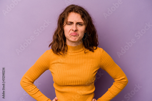 Young caucasian woman isolated on purple background sad, serious face, feeling miserable and displeased. photo