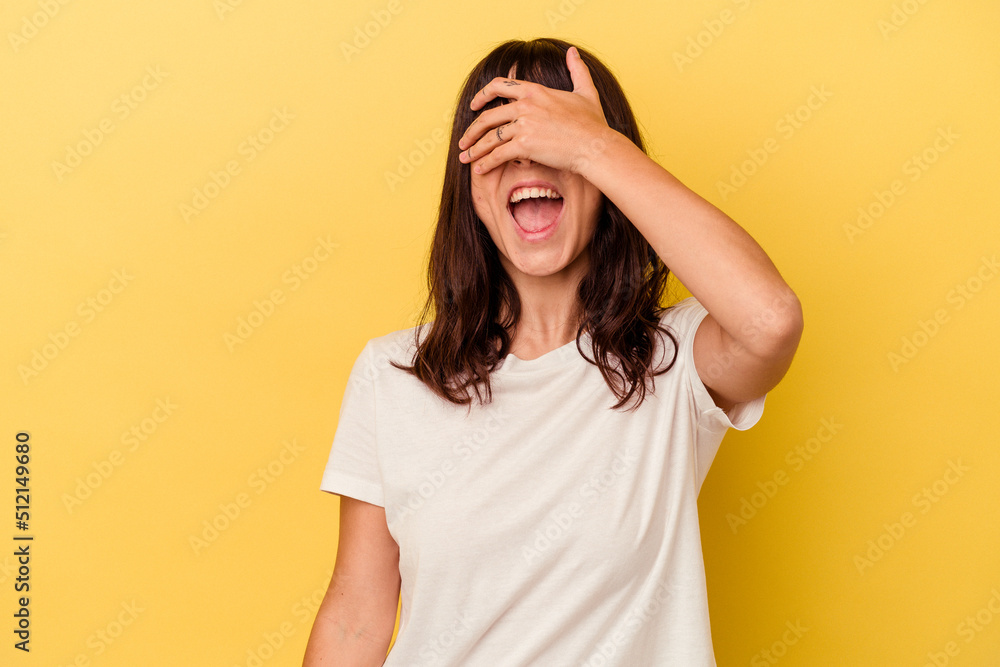 Young caucasian woman isolated on yellow background covers eyes with hands, smiles broadly waiting for a surprise.