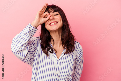 Young caucasian woman isolated on pink background excited keeping ok gesture on eye. © Asier