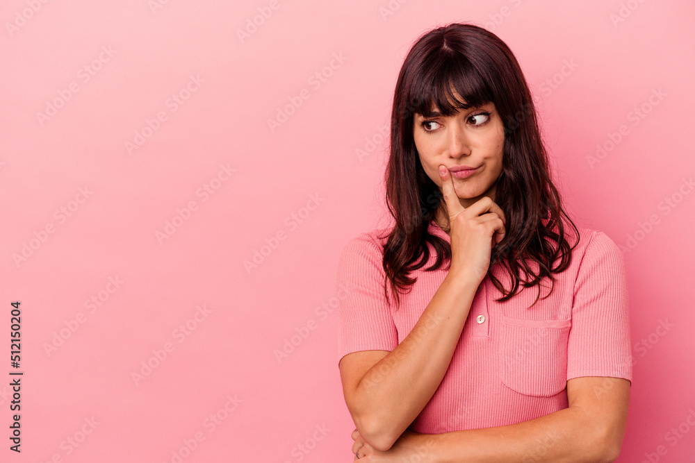 Young caucasian woman isolated on pink background looking sideways with doubtful and skeptical expression. Young caucasian woman isolated on pink background looking sideways with doubtful and skeptical expression.