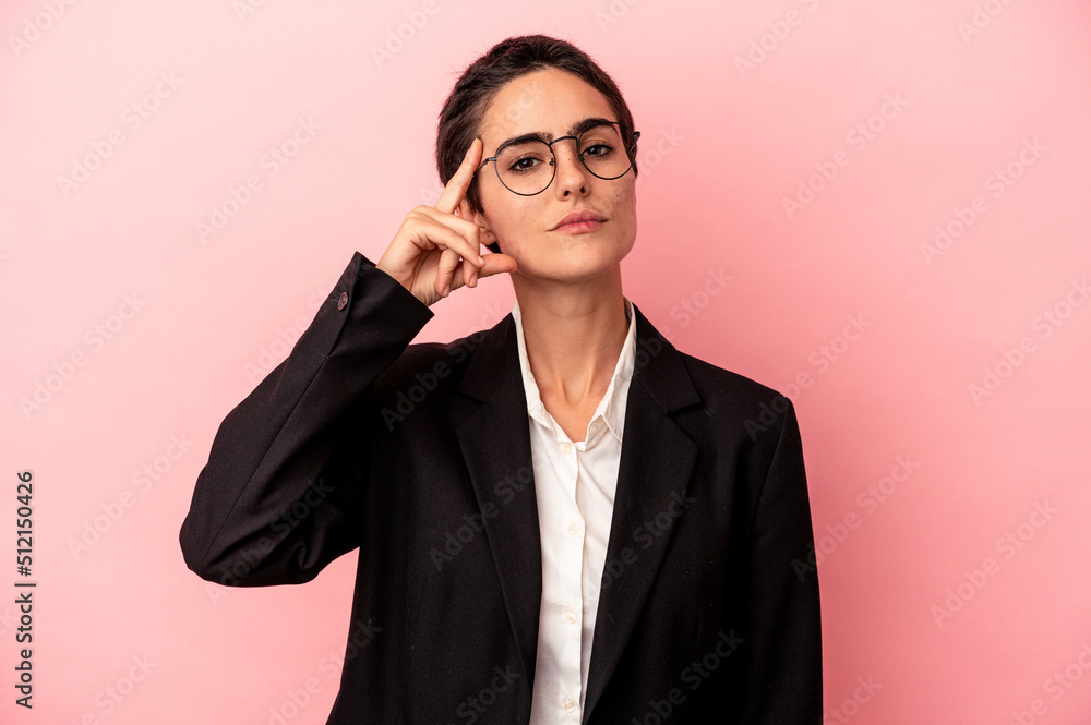 Young business woman isolated on pink background pointing temple with finger, thinking, focused on a task. Young business woman isolated on pink background pointing temple with finger, thinking, focused on a task.