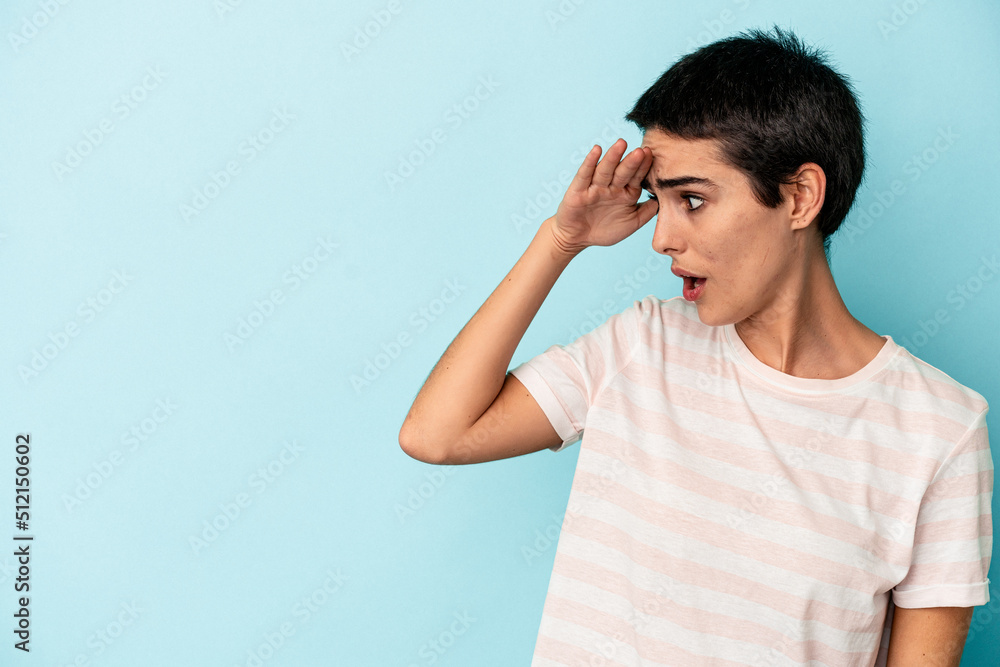 Young caucasian woman isolated on blue background looking far away keeping hand on forehead. Young caucasian woman isolated on blue background looking far away keeping hand on forehead.