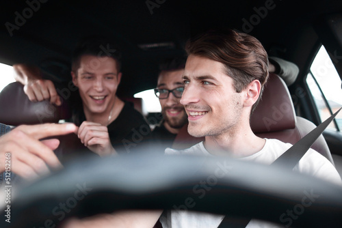 A group of people inside a car, on a road trip