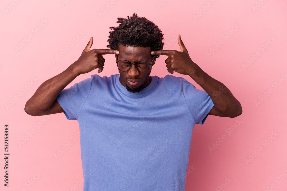 Young african american man isolated on pink background focused on a task, keeping forefingers pointing head. Young african american man isolated on pink background focused on a task, keeping forefingers pointing head.