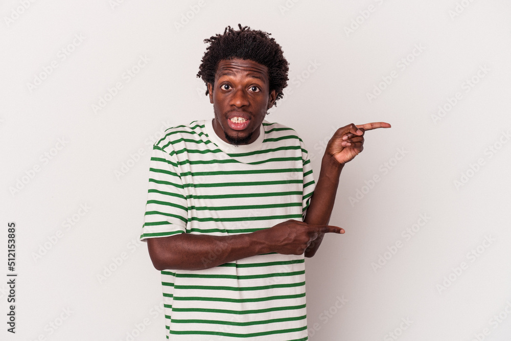 Young african american man isolated on white background shocked pointing with index fingers to a copy space. Young african american man isolated on white background shocked pointing with index fingers to a copy space.