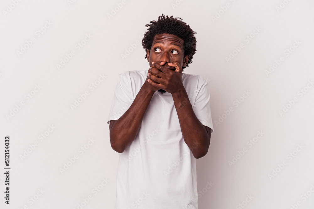 Young african american man isolated on white background thoughtful looking to a copy space covering mouth with hand. Young african american man isolated on white background thoughtful looking to a copy space covering mouth with hand.
