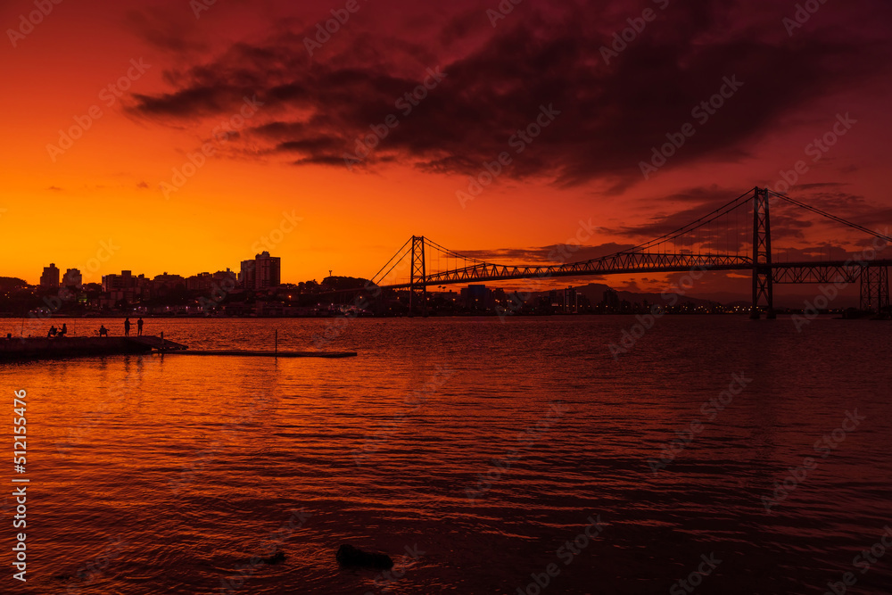 Hercilio luz cable bridge with sunset sky and reflection on water in Florianopolis