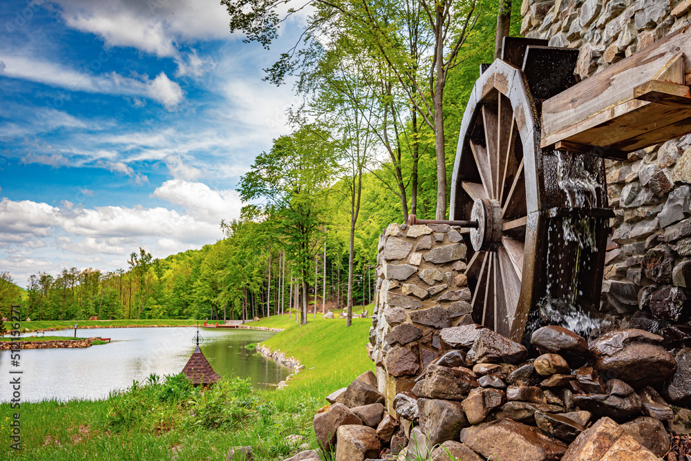 An old stone watermill in a beautiful forest. - obrazy, fototapety, plakaty 