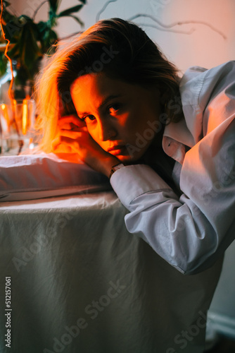Portrait of attractive caucasian woman sitting at table with candles in the evening.