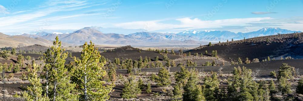 Panorama of distant mountains with lava flows of Craters of the Moon National Monument in foreground