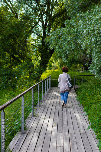 woman walking on wooden deck in the park