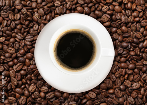 Cup of tasty espresso and roasted coffee beans, top view