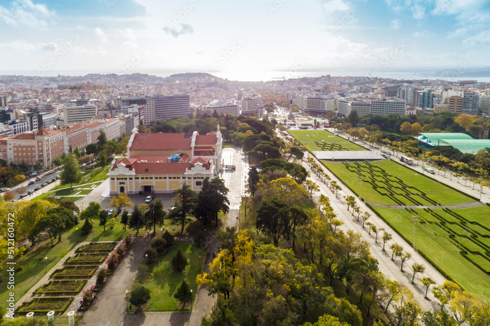 Aerial view of observation deck of Parque Eduardo VII or Park of Eduard the VII Sloped, scenic park featuring tree-lined walking paths, manicured lawns & distant water views in Lisbon 