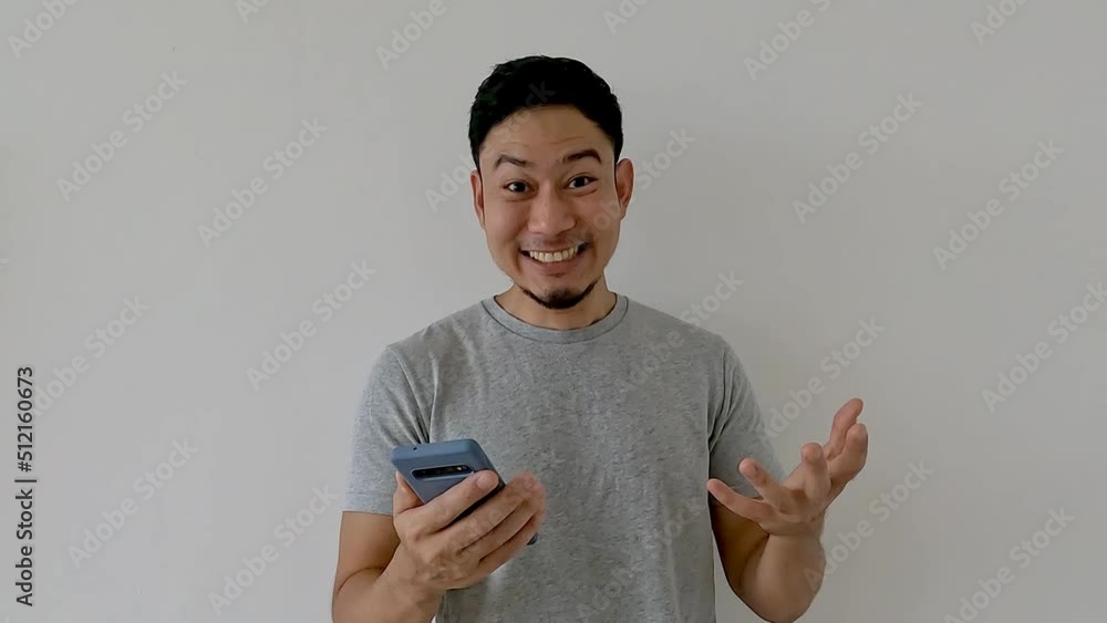 Wow and surprise face asian man use smartphone with copy space of advertisement. Wow and surprise face asian man use smartphone with copy space of advertisement.