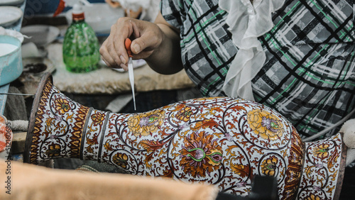 photo of a craftsman making Cloisonné (an ancient technique for decorating metalwork objects with colored material) in china