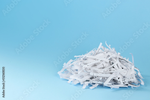 Heap of shredded paper strips on light blue background  space for text