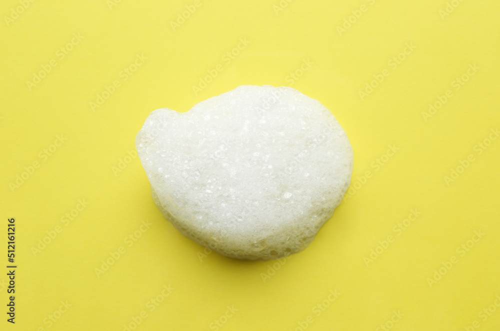 Drop of bath foam on yellow background, top view Drop of bath foam on yellow background, top view