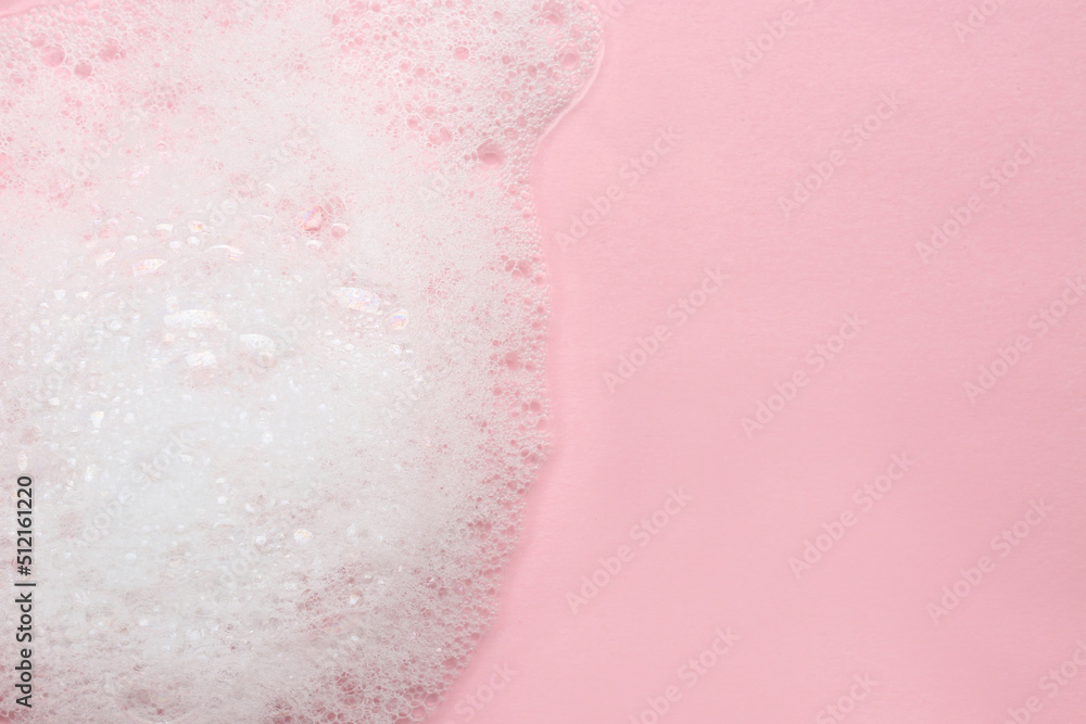 Fototapeta premium Fluffy bath foam on pink background, top view. Space for text