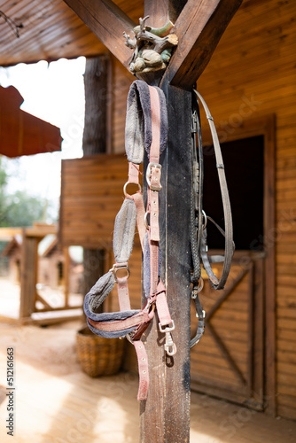 Horse saddles hanging in a barn.