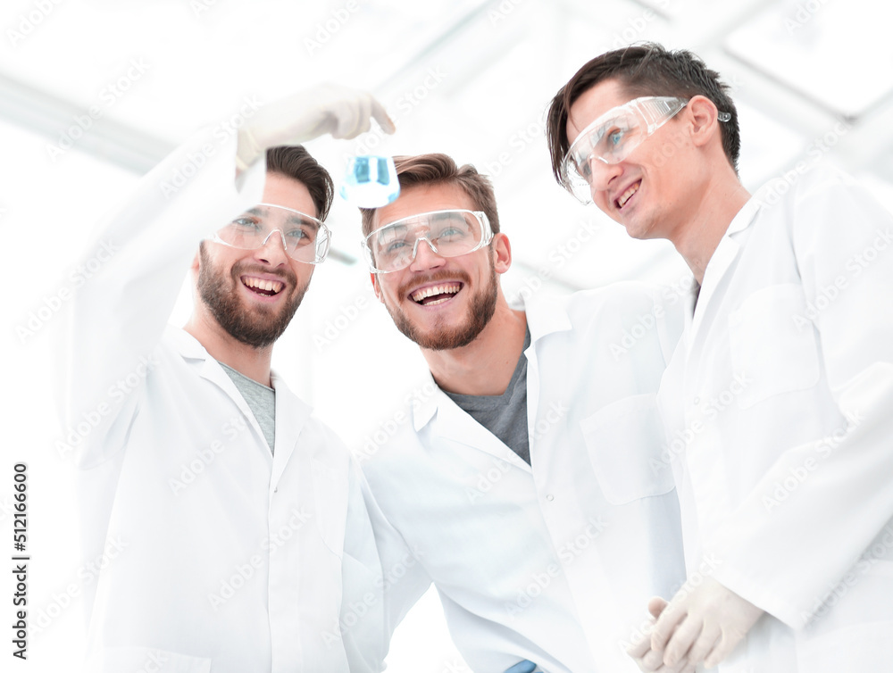 scientists studying the liquid in the beaker. scientists studying the liquid in the beaker.