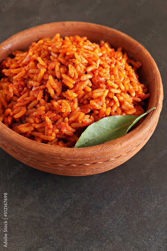 Jollof Rice. Traditional Nigerian spicy rice dish. National Jollof Rice day. Stock Photo Adobe