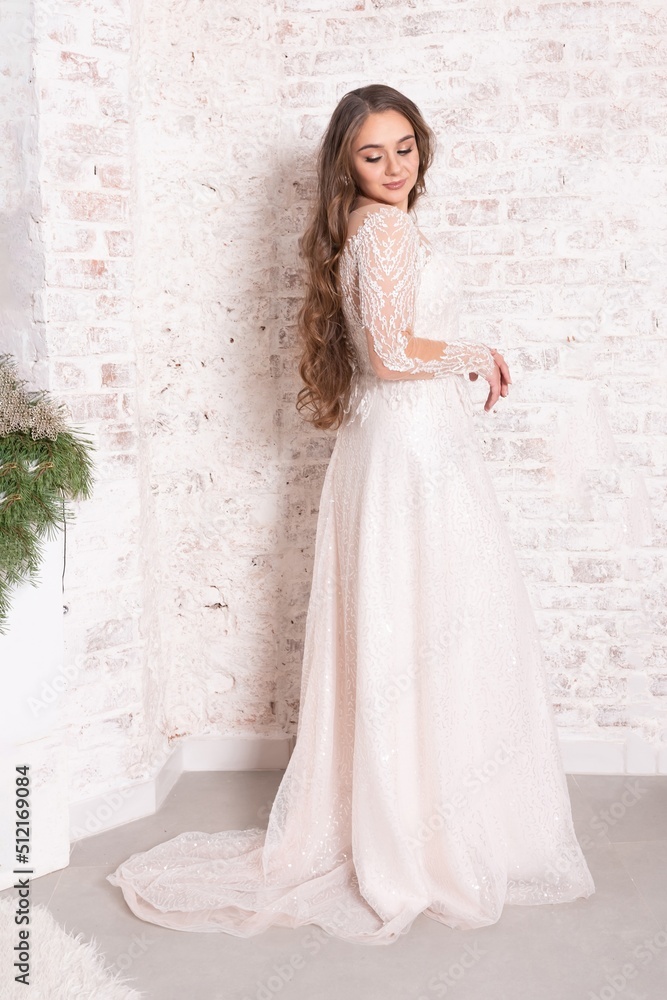 The bride in full growth, against the backdrop of a white brick wall. The bride in full growth, against the backdrop of a white brick wall.