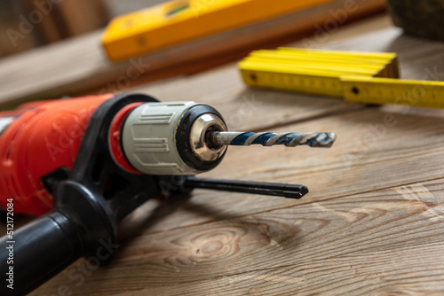 Canvas Print Electric drill tool on carpenter work bench table closeup view