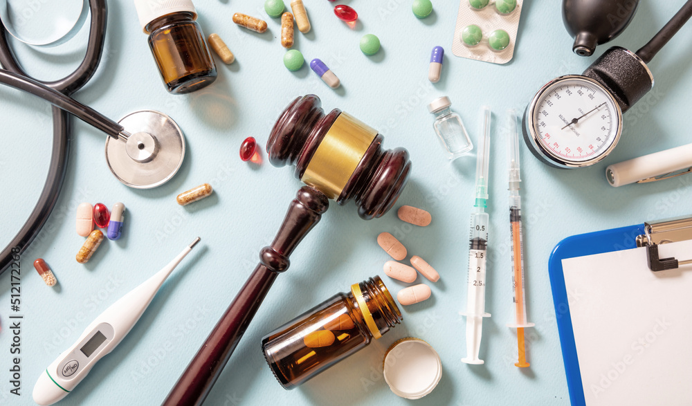 Health and Law flat lay. Judge gavel, medical stethoscope and medicine
